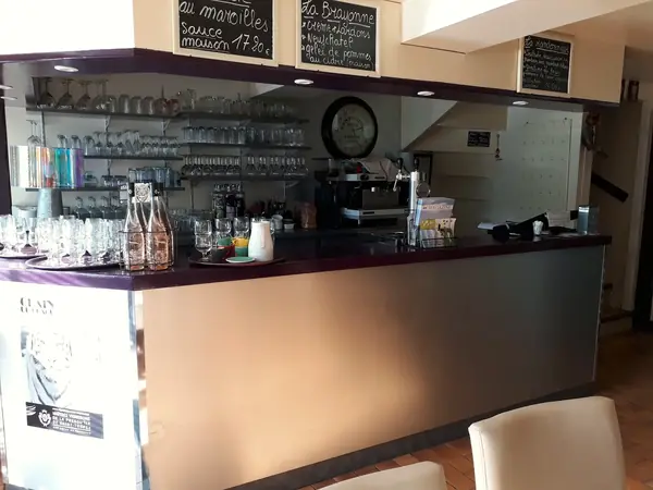 Comptoir du Pinocchio, laqué bordeaux, avec sa verrerie alignée, la machine à café et les ardoises manuscrites accrochées au-dessus.