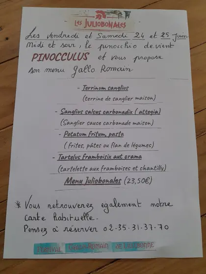 Annonce manuscrite du restaurant sur une table en bois : pendant les Juliobonales, le Pinocchio devient Pinocculus et propose un menu gallo-romain.